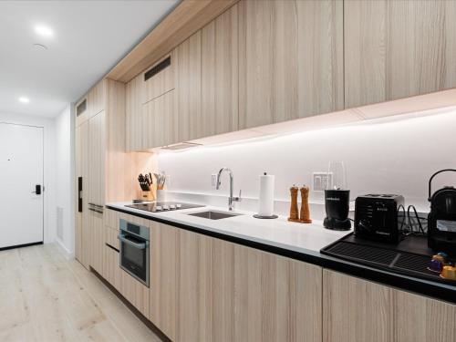 a kitchen with wooden cabinets and a sink at Stylish Studio in Downtown Location in Miami