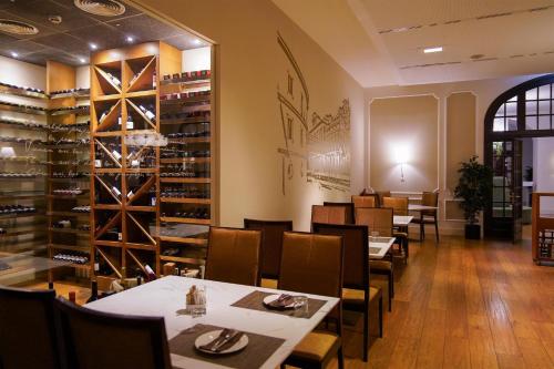 a dining room with tables and chairs and wine racks at Blau Hotel Las Caldas, a member of Radisson Individuals in Las Caldas