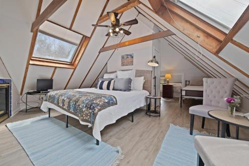 a attic bedroom with a bed and a chair at Brook Farm Inn in Lenox