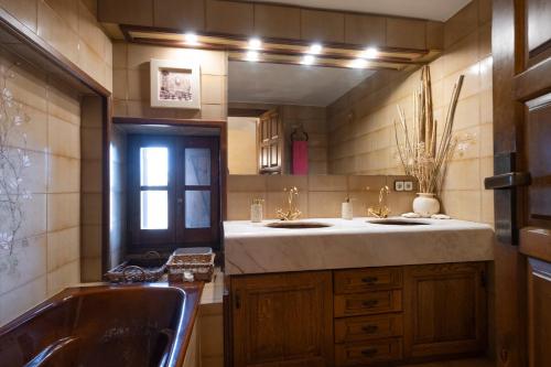 a bathroom with two sinks and a large mirror at Pla de Moixons in Oristá