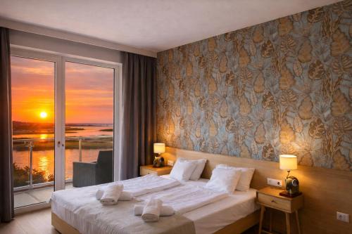a bedroom with a bed with a view of the ocean at VR Spa Apartman in Velence