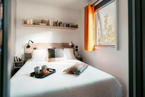 a bedroom with a bed with a tray on it at Camping Au Coeur de Vendome in Vendôme