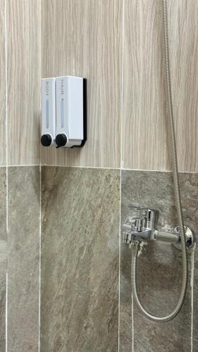 a bathroom with a shower with a faucet at Sky Tau Hostel in Almaty