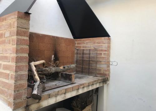 a brick fireplace with a metal grate on it at El Chalet de Lola in Playa de Miramar
