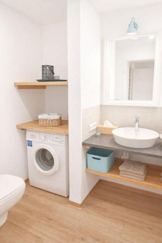 a bathroom with a washing machine and a sink at Ferienwohnung Gartenglück im Mölltal in Semslach
