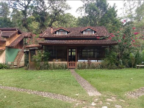 a house with a green yard in front of it at Pousada Céu aberto in Núcleo Mauá