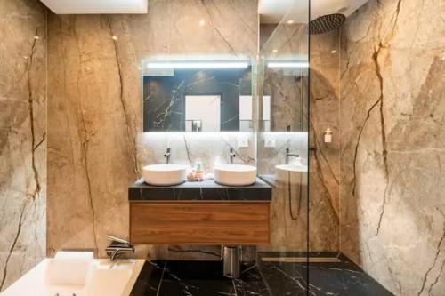 a bathroom with two sinks and a mirror at Romantic getaway with Balneo Centre Lorient in Lorient