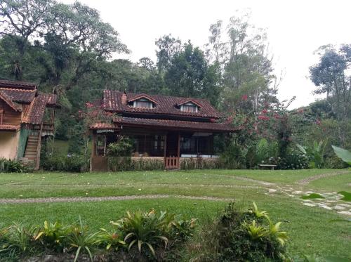 a house in a field with a grass yard at Pousada Céu aberto in Núcleo Mauá