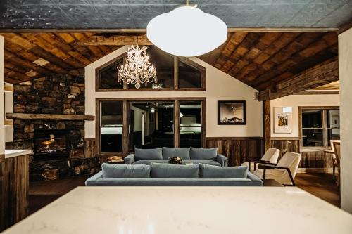 a living room with a blue couch and a chandelier at Bootleggers Lodge on Lake Nokomis in Tomahawk