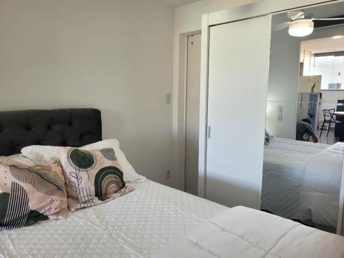 a bedroom with a bed and a mirror at Flat Praia Itacoatiara in Niterói