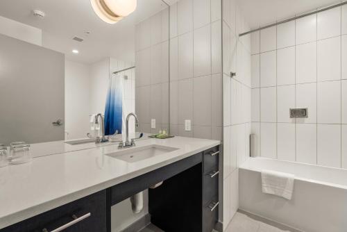 a white bathroom with a sink and a tub at The Simon at Simon Fraser University in Burnaby