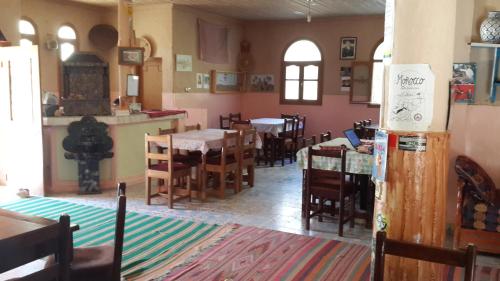 a dining room with tables and chairs in a restaurant at Kasbah Hotel Camping Jurassique in Ifri