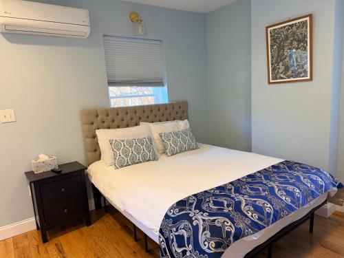 a bedroom with a bed with a blue and white comforter at Sunny&Cozy Apartment in University City Walk to Drexel&Near UPenn in Philadelphia