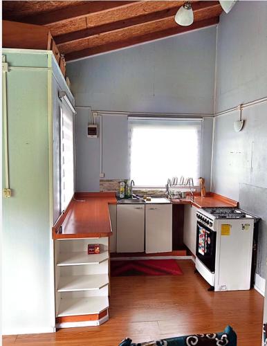 a kitchen with a sink and a stove at Cabañas "Parada Tentelhué" in Rolecha