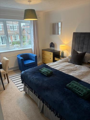 a bedroom with a bed and a chair and a window at SeaCross Sheringham Norfolk Coast 4beds, sleeps 7 in Sheringham