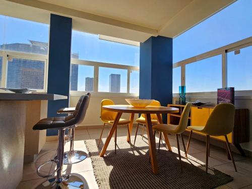 a dining room with a table and chairs and windows at Alameda central, Juárez 52 in Mexico City