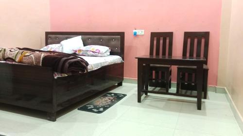 a bedroom with two chairs and a bed and a table at Kamla Sadan Palace in Ayodhya