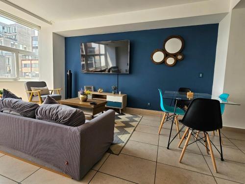 a living room with a couch and a blue wall at Alameda central, Juárez 52 in Mexico City