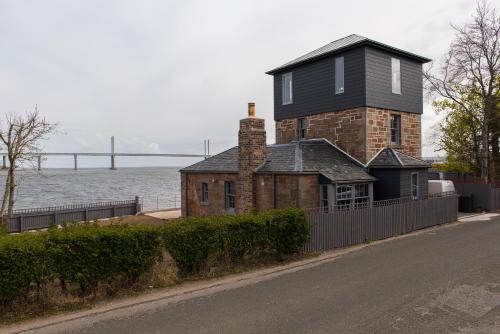 a house on the side of a road next to the water at Tangle Tower in Inverness