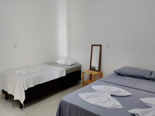 a bedroom with two beds and a mirror on a table at Pousada Kaa - Natureza e Sossego em Itacaré in Itacaré