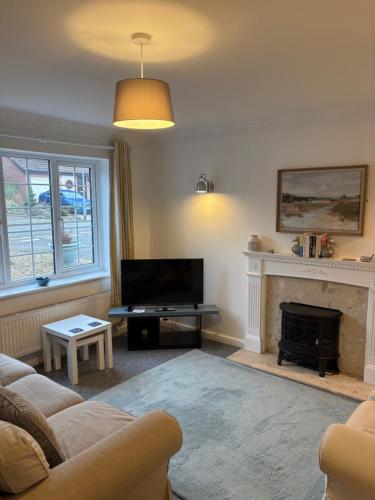 a living room with a couch and a fireplace at SeaCross Sheringham Norfolk Coast 4beds, sleeps 7 in Sheringham