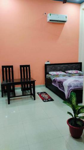 a bedroom with a bed and a table and chairs at Kamla Sadan Palace in Ayodhya