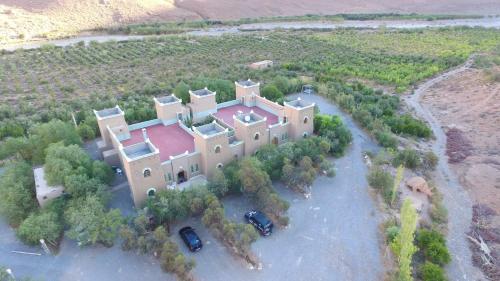 an aerial view of a large house with two cars parked at Kasbah Hotel Camping Jurassique in Ifri