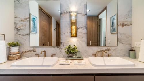 a bathroom with two sinks and two mirrors at Modern Seaside Retreat Boasting Unforgettable Scenery in Puerto Peñasco
