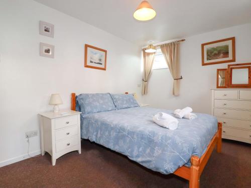 a bedroom with a bed with two towels on it at Seaside Apartment in Looe