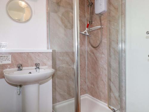 a bathroom with a sink and a shower at Seaside Apartment in Looe