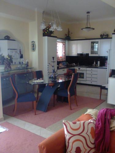 eine Küche und ein Wohnzimmer mit einem Tisch und Stühlen in der Unterkunft Evgenia Apartment in Antikes Epidauros
