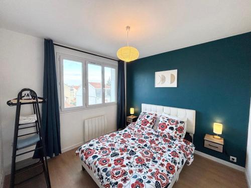 a bedroom with a bed with a floral bedspread at Le Robespierre - Parking privé - 5min gare in Reims