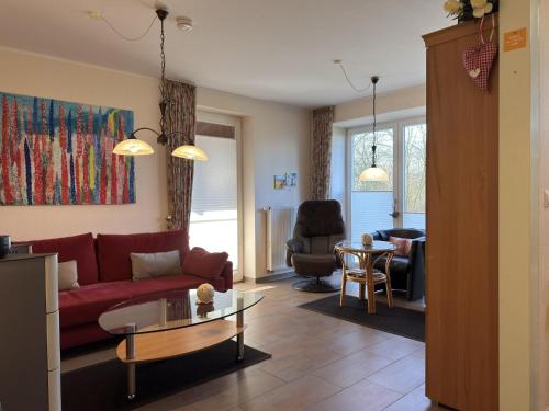 a living room with a red couch and a table at Ferienhaus in Lindern mit Garten & Terrasse in Werlte