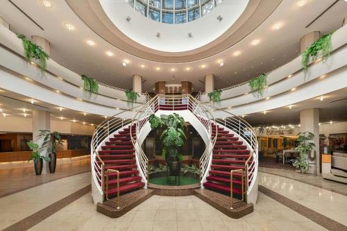 a lobby with a spiral staircase in a building at Leonardo Hotel Weimar in Weimar