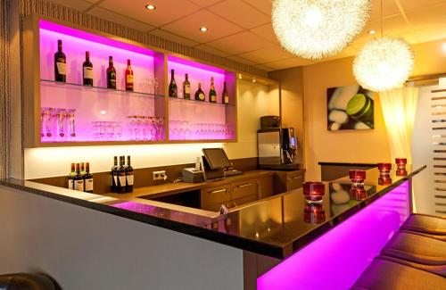 a bar with pink lights in a room at Leonardo Hotel Nürnberg in Nuremberg