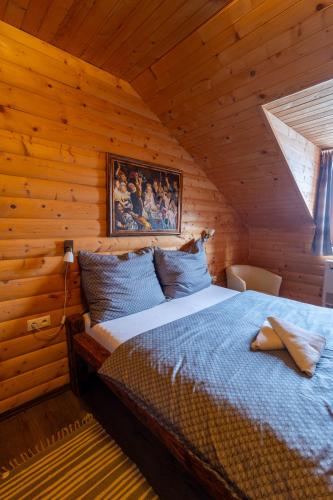 a bedroom with a bed in a wooden cabin at István Pince a penzión in Šahy