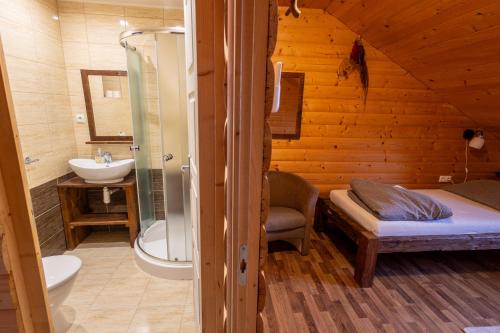a bathroom with a bed and a shower and a sink at István Pince a penzión in Šahy