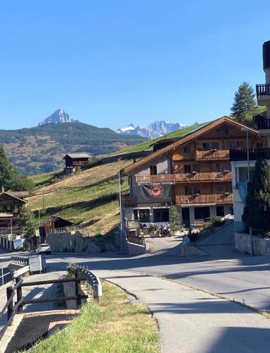 a building with benches in front of a mountain at Alte Bock 2.0 in Grächen