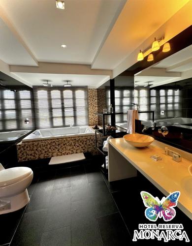 a bathroom with a bath tub and a toilet at Hotel Reserva Monarca in Salento
