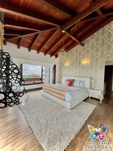 a bedroom with a large bed and a large rug at Hotel Reserva Monarca in Salento