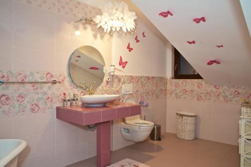 a bathroom with a sink and a mirror at Pensiunea "La Nasu" in Fîntînele