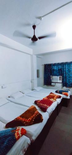 three beds in a room with a ceiling at THE Temple View ''Near Kashi Vishwanath'' in Varanasi
