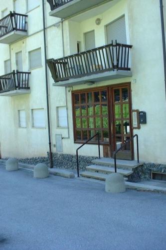 a building with stairs leading to a glass door at Apartment 'Il Capriolo by Interhome in Sauze d'Oulx