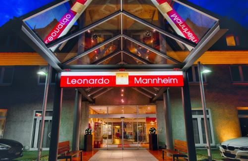 a building with a red sign in front of it at Leonardo Hotel Mannheim-Ladenburg in Ladenburg