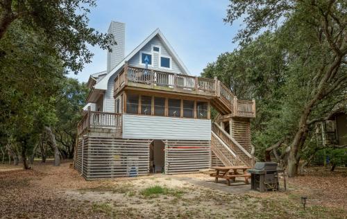 a large house with a deck and a bench at Pappia - Duck, Sanderling, Oceanside, 150 Yards to Beach, on Lake, Community Pool in Duck