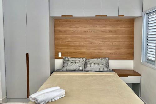 a bedroom with a bed with a wooden headboard at Apartamento Studio em São Bernardo in São Bernardo do Campo