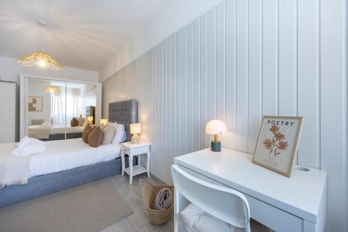 a bedroom with a bed and a desk in it at Albufeira City Centre Apartment with Pool in Albufeira