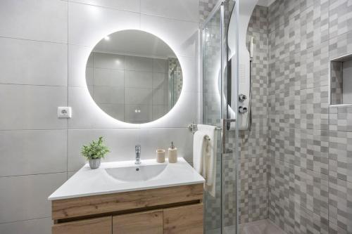 a bathroom with a sink and a mirror at Albufeira City Centre Apartment with Pool in Albufeira