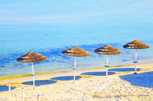 a group of umbrellas on a beach near the water at Smeralda Apartment - Golfo Aranci in Golfo Aranci