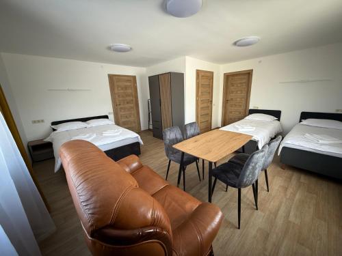 a room with two beds and a couch and a table at SALGIRDO svečių namai in Kelmė